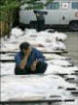 A man sits by dead bodies of the Beslan hostage-taking victims at the morgue in Vladikavkz, North Ossetia.(AFP/Viktor Drachev) (Click for Large Photo)